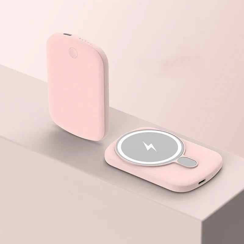 Magsafe magnetic wireless power bank in four colours: black, purple, pink, and white, next to an iPhone.