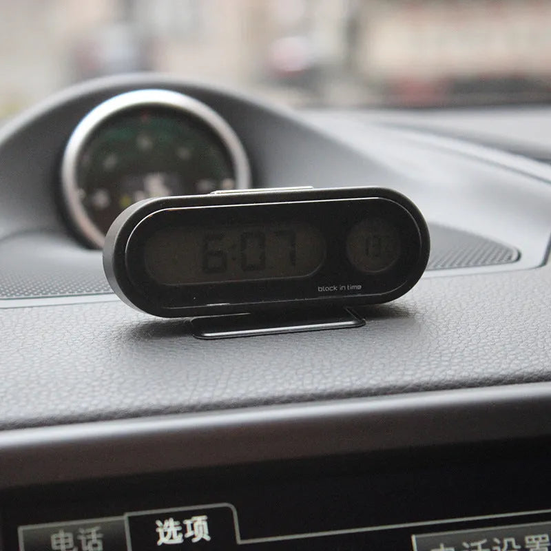 Black car dashboard clock thermometer with luminous LED display showing time and temperature