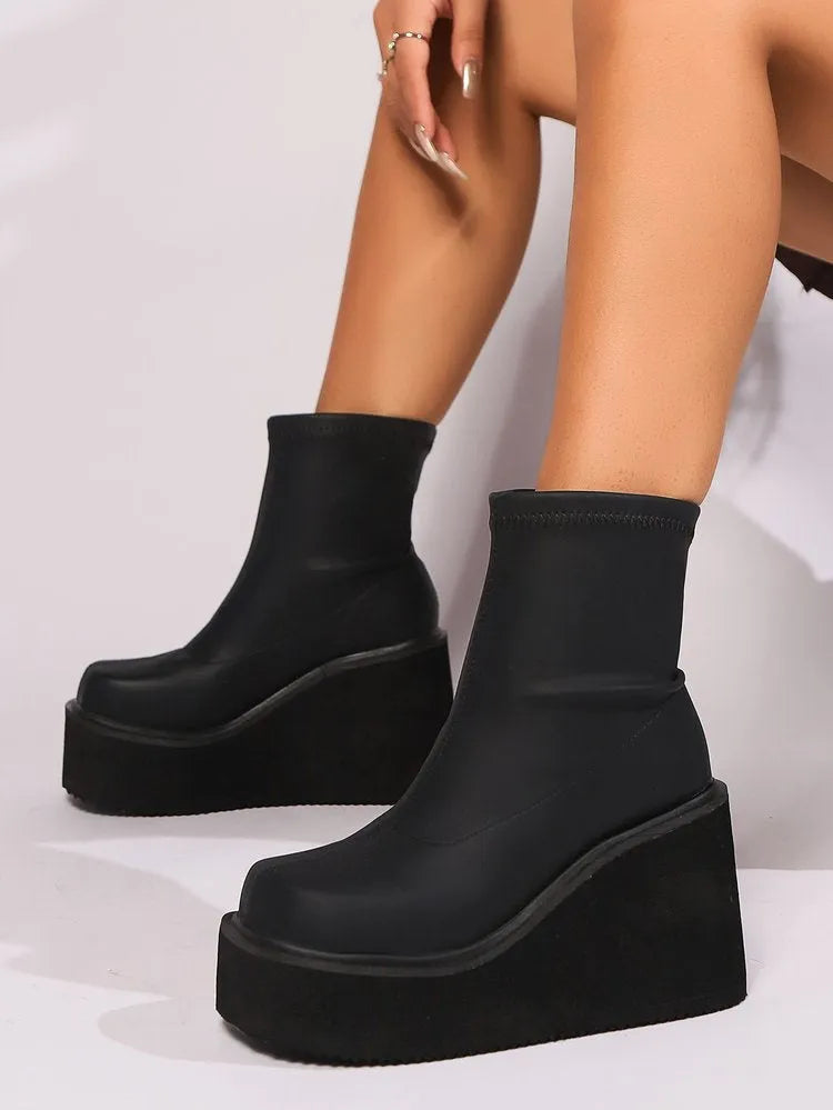 Plus size women's black wedge heel boot with a round toe and waterproof platform sole.