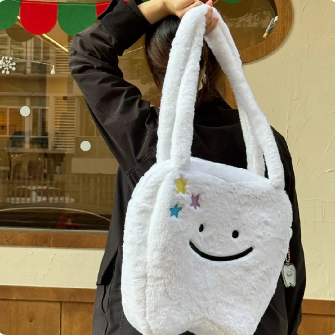White plush tote bag with tooth decoration and shoulder strap showing zip opening