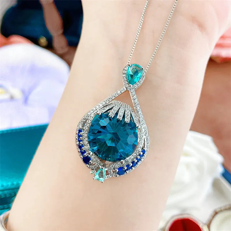 Blue geometric crystal pendant necklace on a water wave chain for women.
