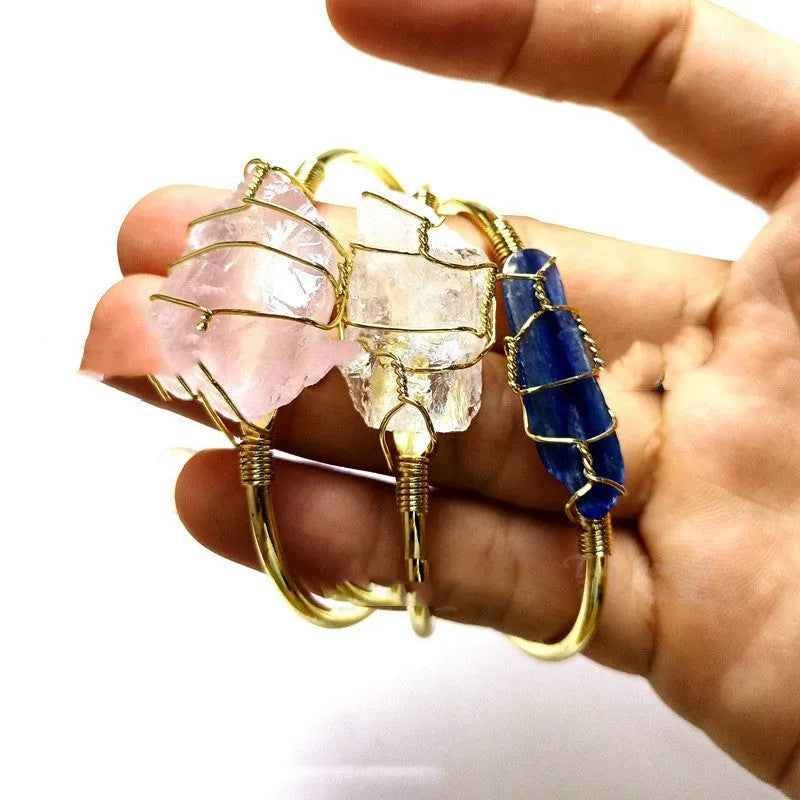 Natural rough crystal bracelet with gold geometric winding on a wrist, showing bohemian style.