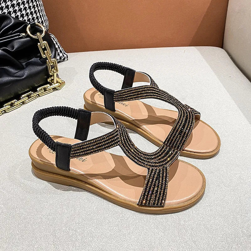 Gold women's patent leather sandals with rhinestone decoration on the strap and a non-slip sole.