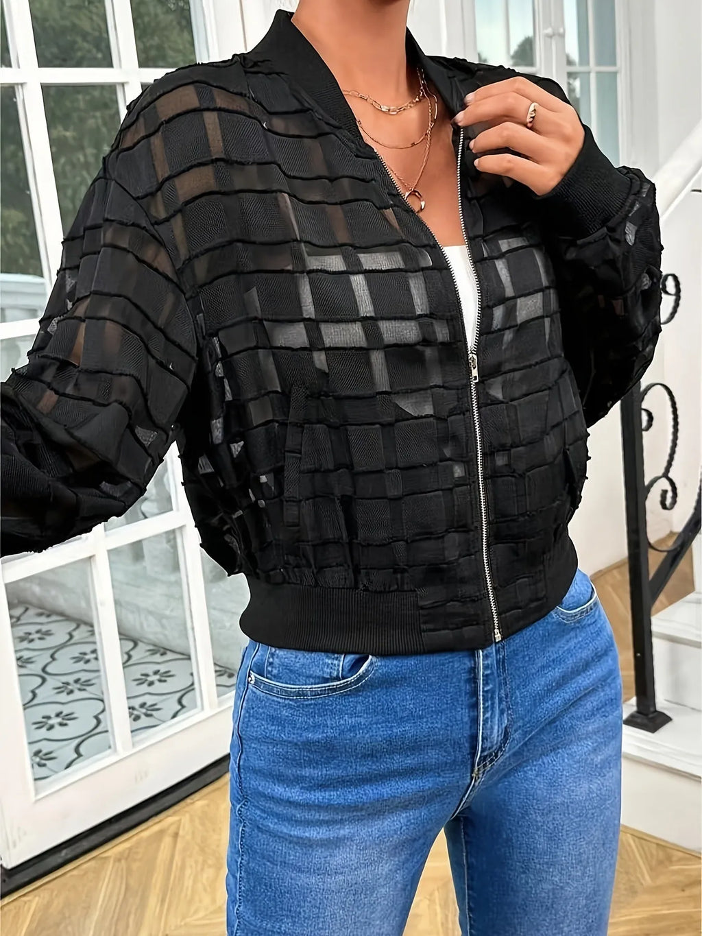 Black semi-transparent women's jacket with geometric pattern, thread zipper, and long sleeves.
