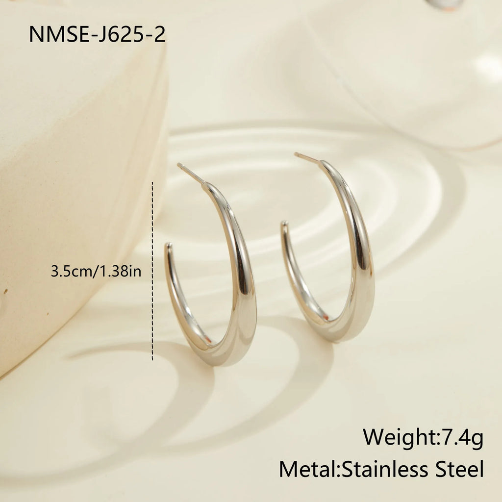 A pair of simple round titanium steel hoop earrings for women, shown in gold and steel finishes.