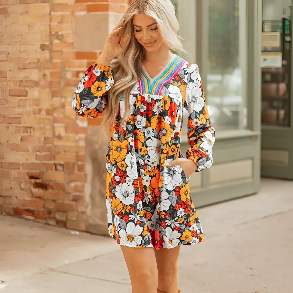 Orange floral and striped print mini dress with lace trim, long sleeves, and a V-neck.