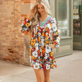 Orange floral and striped print mini dress with lace trim, long sleeves, and a V-neck.