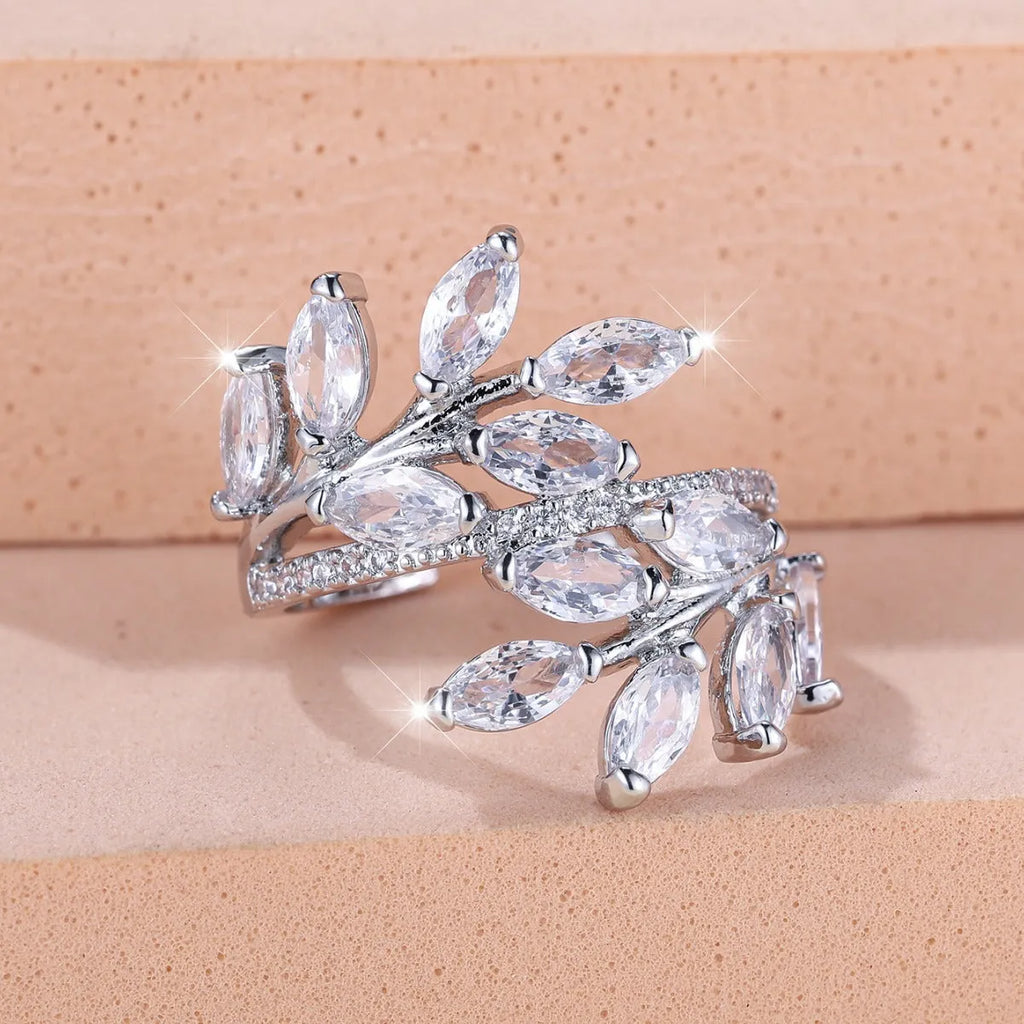 Adjustable copper leaf-shaped ring with zircon gemstone colour options on a white background.