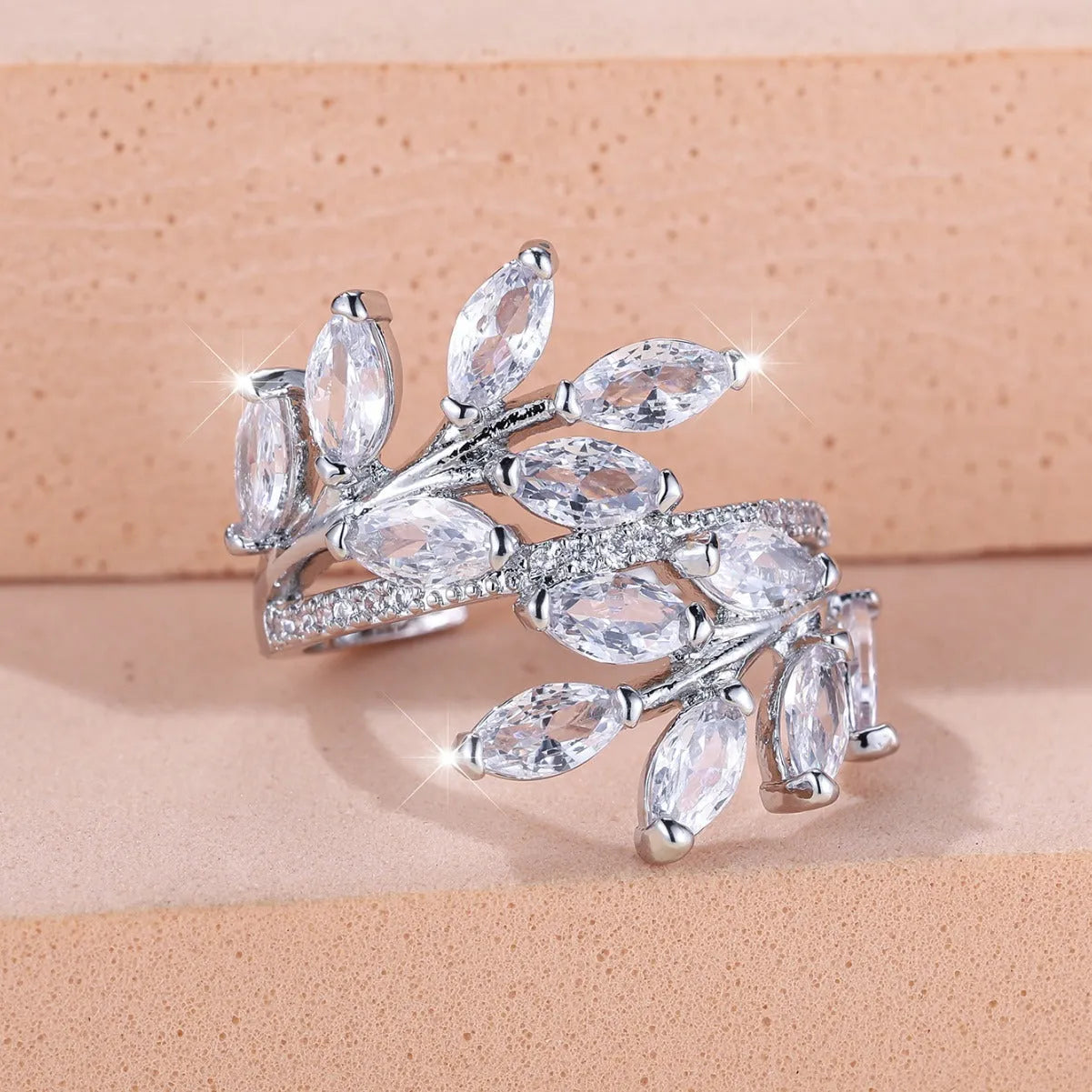 Adjustable copper leaf-shaped ring with zircon gemstone colour options on a white background.