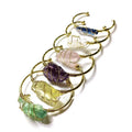 Natural rough crystal bracelet with gold geometric winding on a wrist, showing bohemian style.