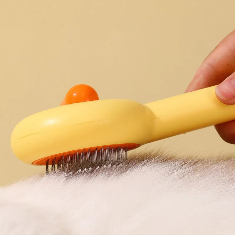 Small yellow duck-shaped pet comb with needle bristles for hair removal on cats and dogs.