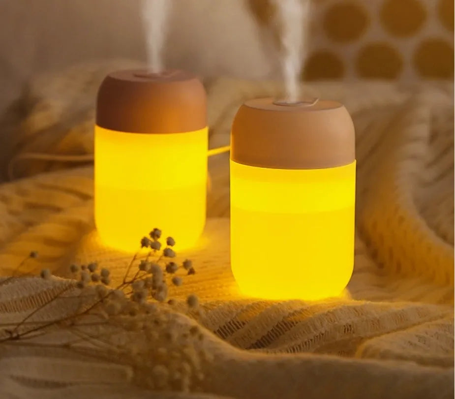 White cylindrical mini USB humidifier on wooden surface with charging cable
