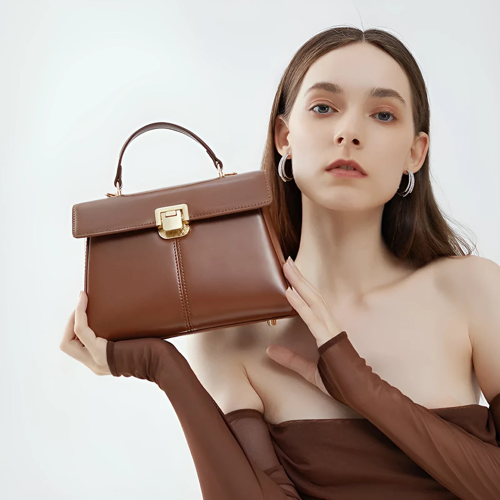 Black leather women's shoulder bag with vachette clasp showing horizontal square shape and adjustable strap
