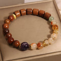 Women's bracelet with yellow crystal, amethyst, ebony, pearls, and rhinestones.
