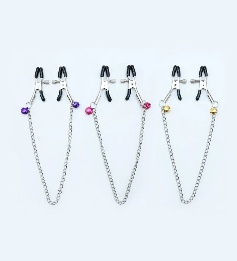 Red bell nipple clamp pair with chain attachment on a dark background