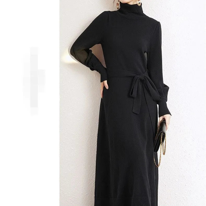 Loose turtleneck knit dress for women with long sleeves, elastic waist, and a big hem in a solid colour.