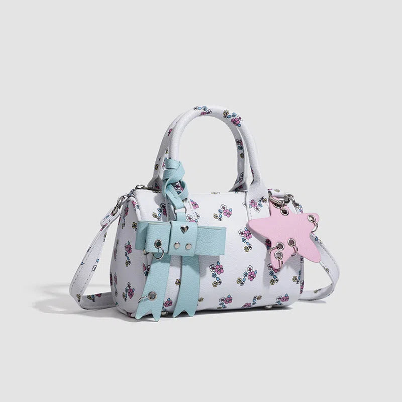 White PU hand-held shoulder bag with petite floral bow accessory on display