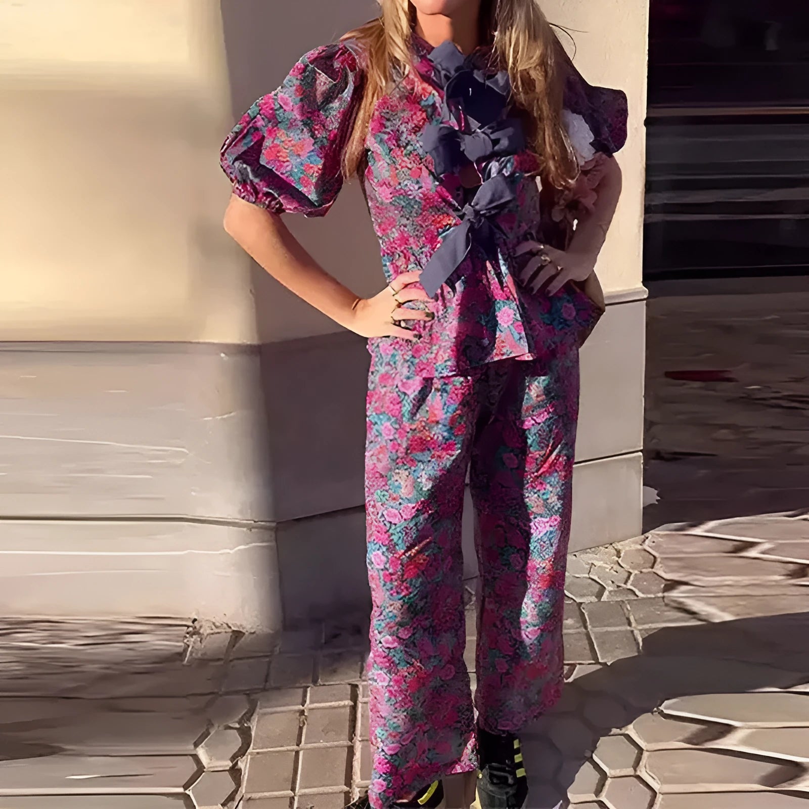 Women's floral print two-piece trouser suit with puff sleeve top and matching trousers.