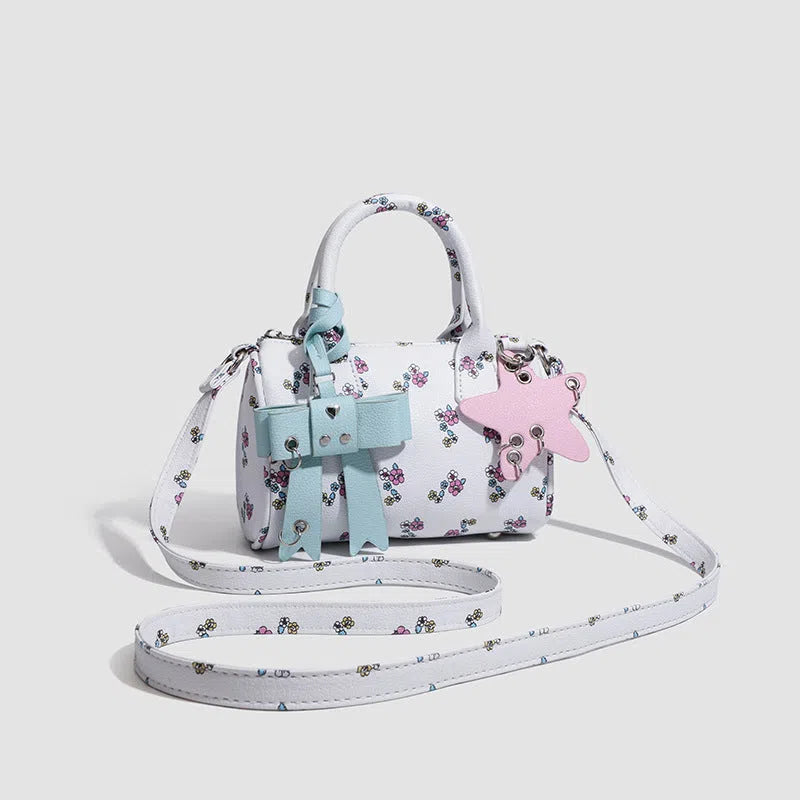 White PU hand-held shoulder bag with petite floral bow accessory on display