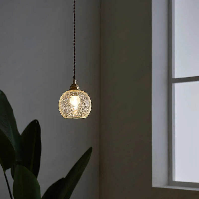 Retro brass and glass ball chandelier ceiling light with copper frame and spherical shade.