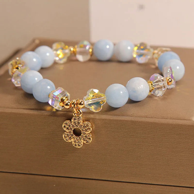 Women's aquamarine crystal bracelet with a four-leaf clover charm and pearl decorative accents