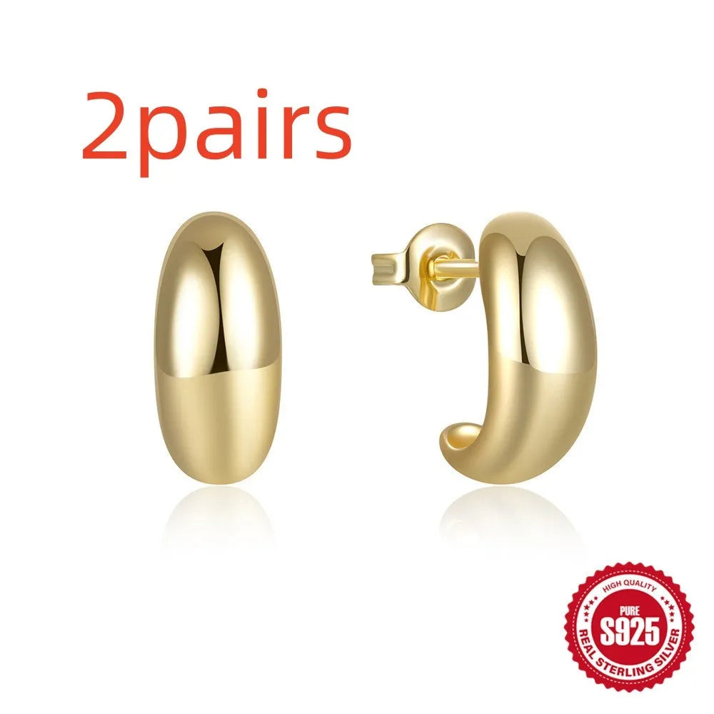 A single glossy C-shaped sterling silver stud earring on a plain background, showing gold and silver finish options.