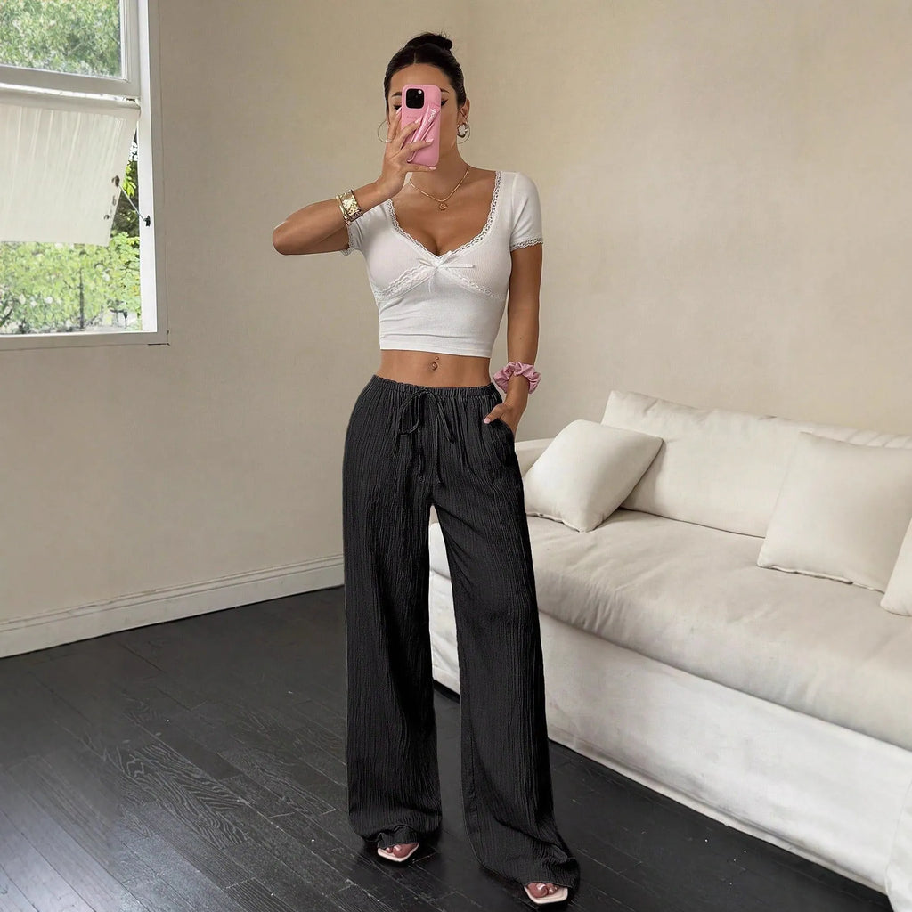 Women's black wide leg trousers with lace-up waist trimming detail showing mid-waist design