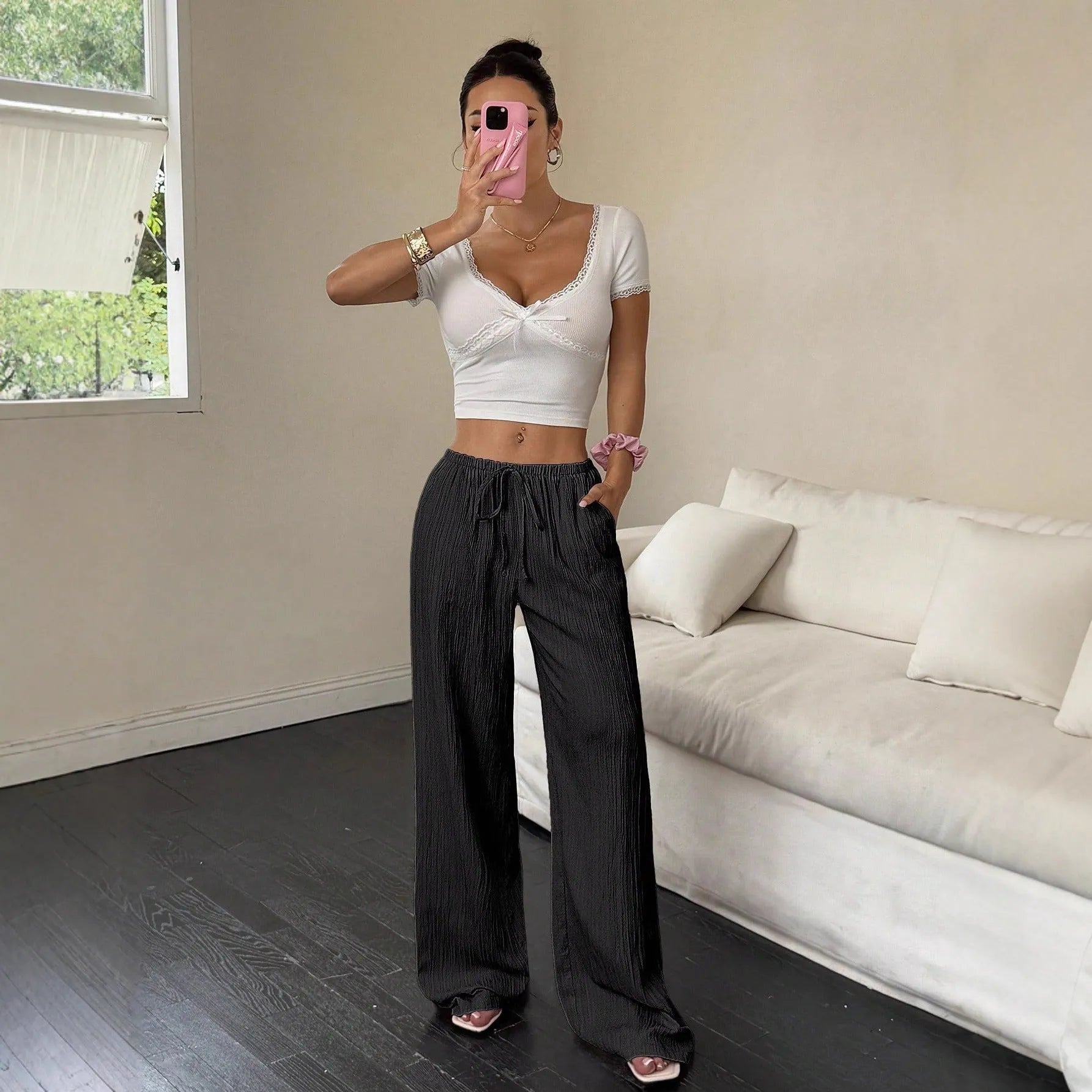 Women's black wide leg trousers with lace-up waist trimming detail showing mid-waist design