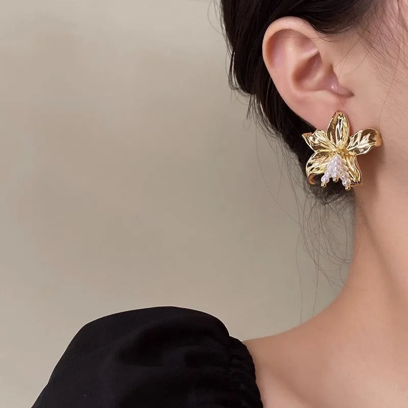A pair of gold H1795 flower-shaped earrings for women with a Seiko-treated metal finish.