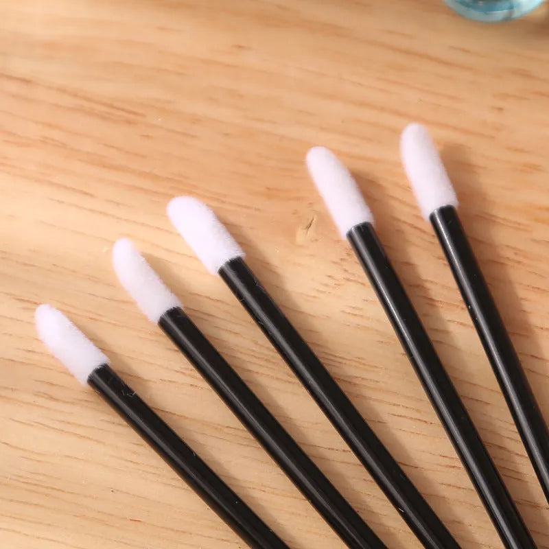 Pack of disposable lip brushes with flocked heads and coloured handles for lipstick application.