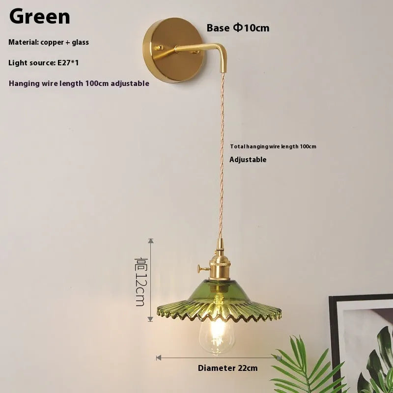 Brass lotus wall lamp with glass shade in six colour options on a wall