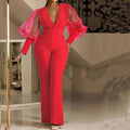 Slim fit wide leg jumpsuit with mesh stitching detail on the sleeves and an elastic waistband.