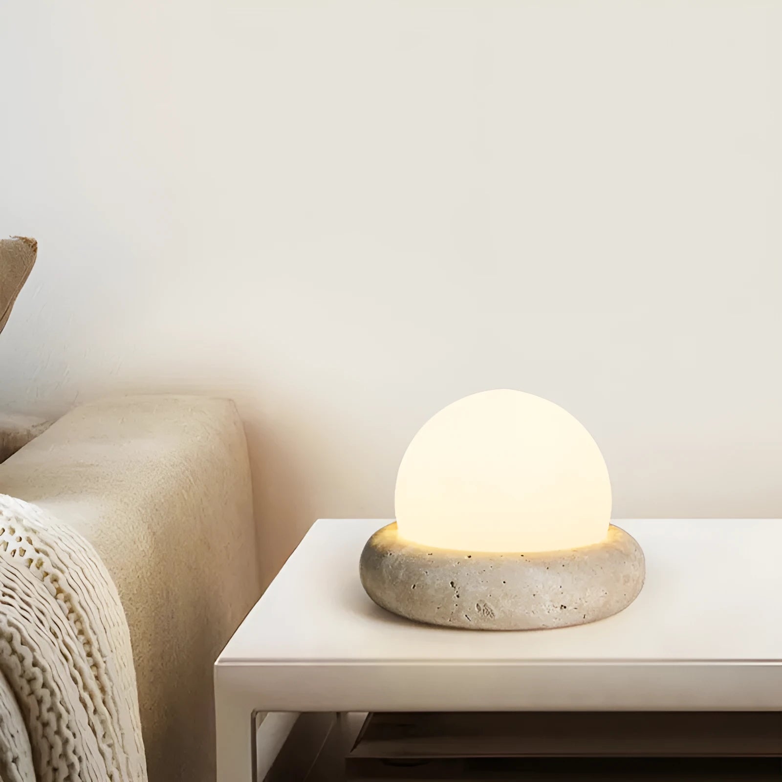 Cream coloured bedside night light with remote control on wooden table