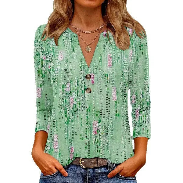 Women's loose fit V-neck t-shirt with a colourful 3D printed pattern, on a hanger.