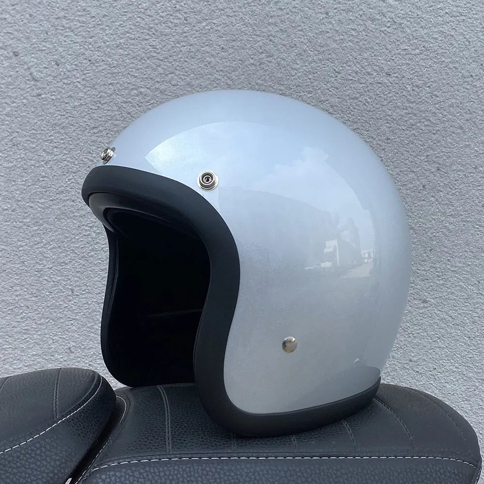 Cement grey retro half motorcycle helmet with glass fibre shell on a plain background.