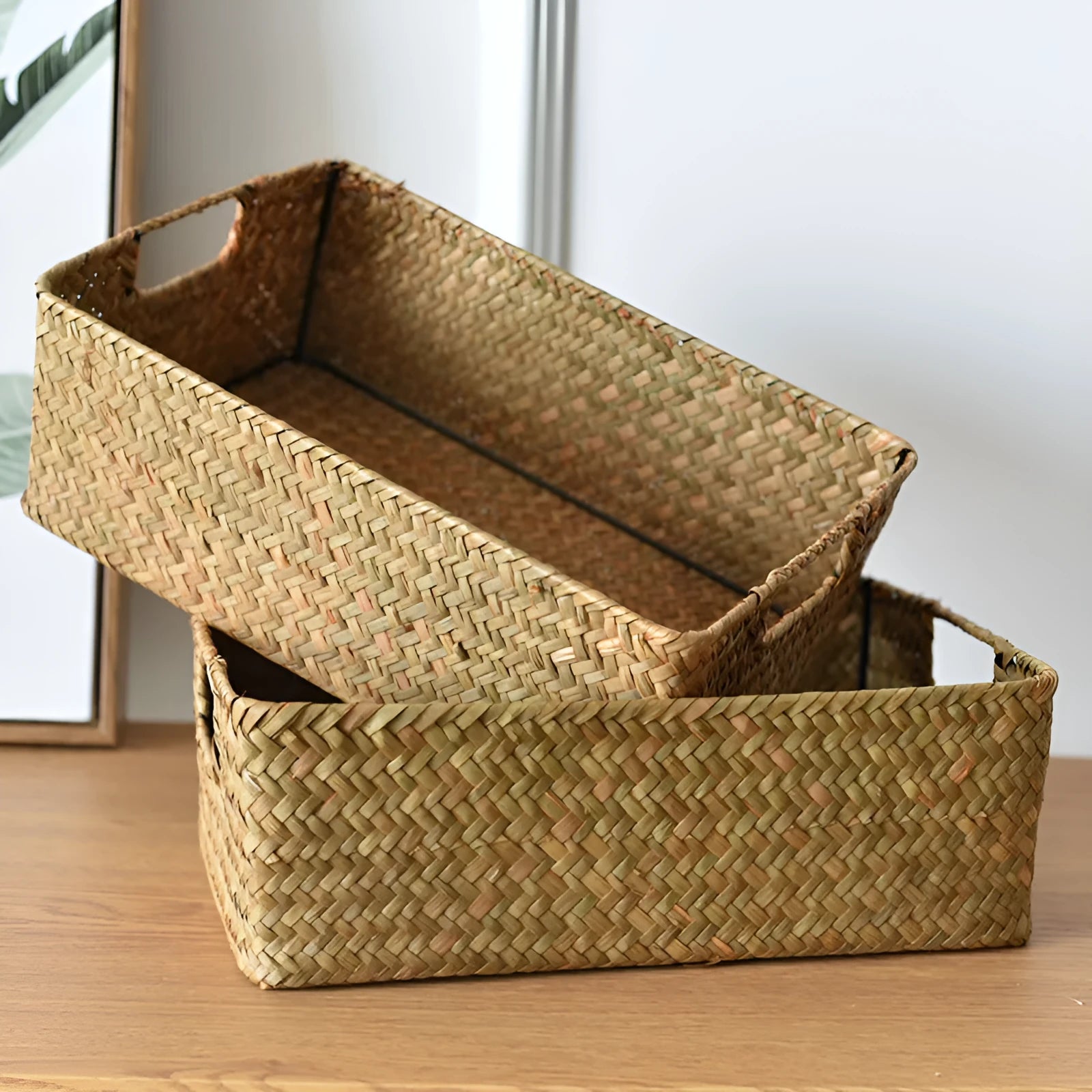 Handmade straw woven rectangular storage basket in natural grass fibre on a shelf
