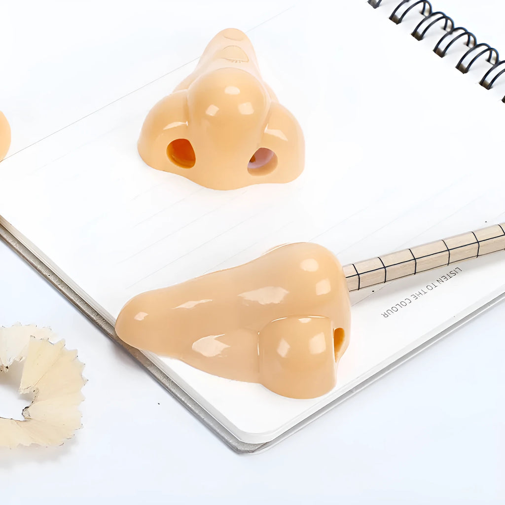 Flesh colour plastic student pencil sharpener with large nostril hole showing geometry shape