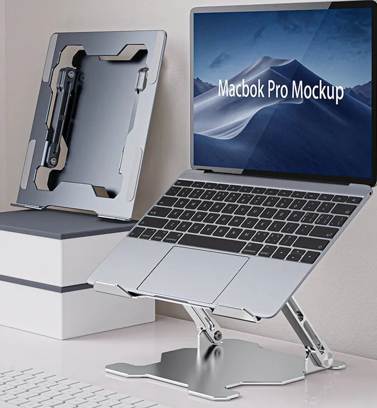 Grey aluminium adjustable laptop stand holding a silver laptop on a wooden desk.