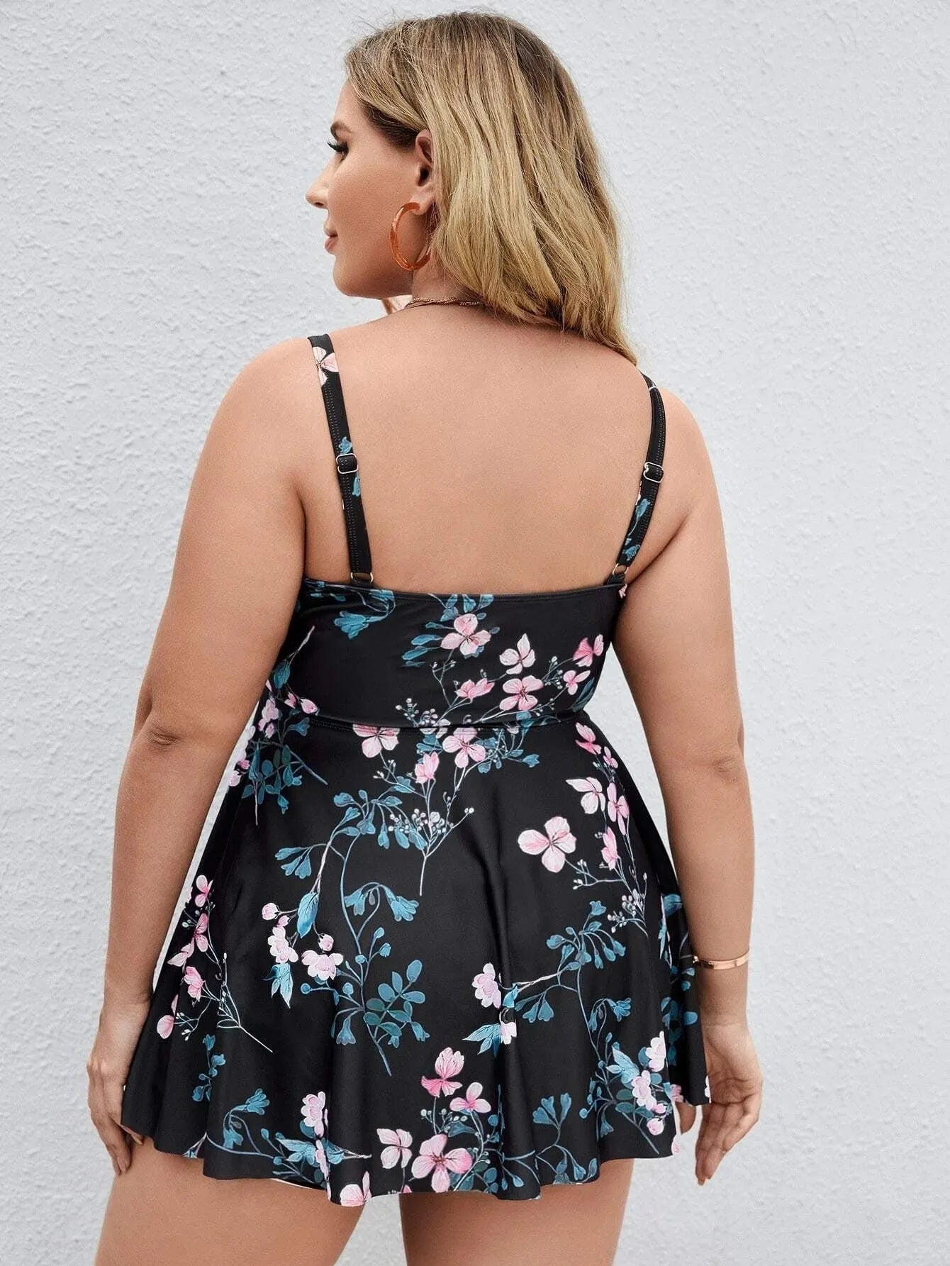 Women's floral print one-piece swimsuit on a hanger, showing split colour design and stretchy polyester fabric for plus sizes.