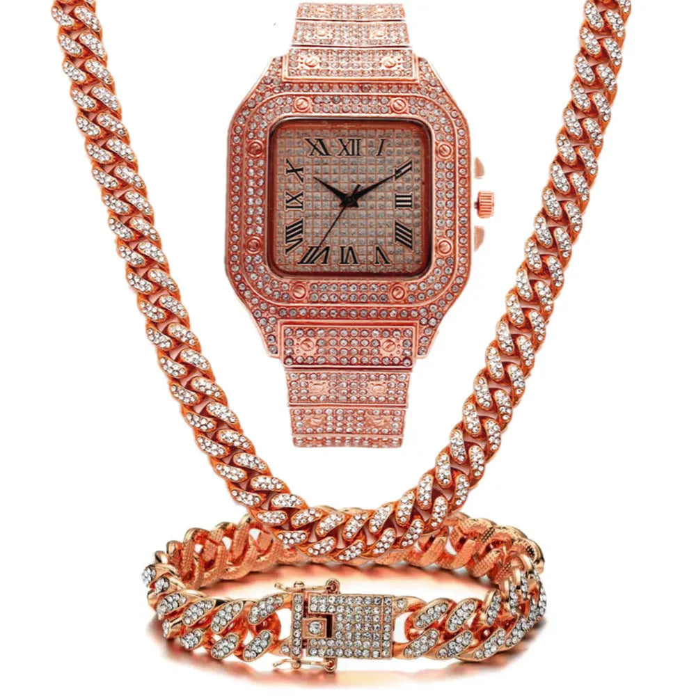 Gold Roman numeral square watch with black mesh band, bracelet, and necklace set on a table.