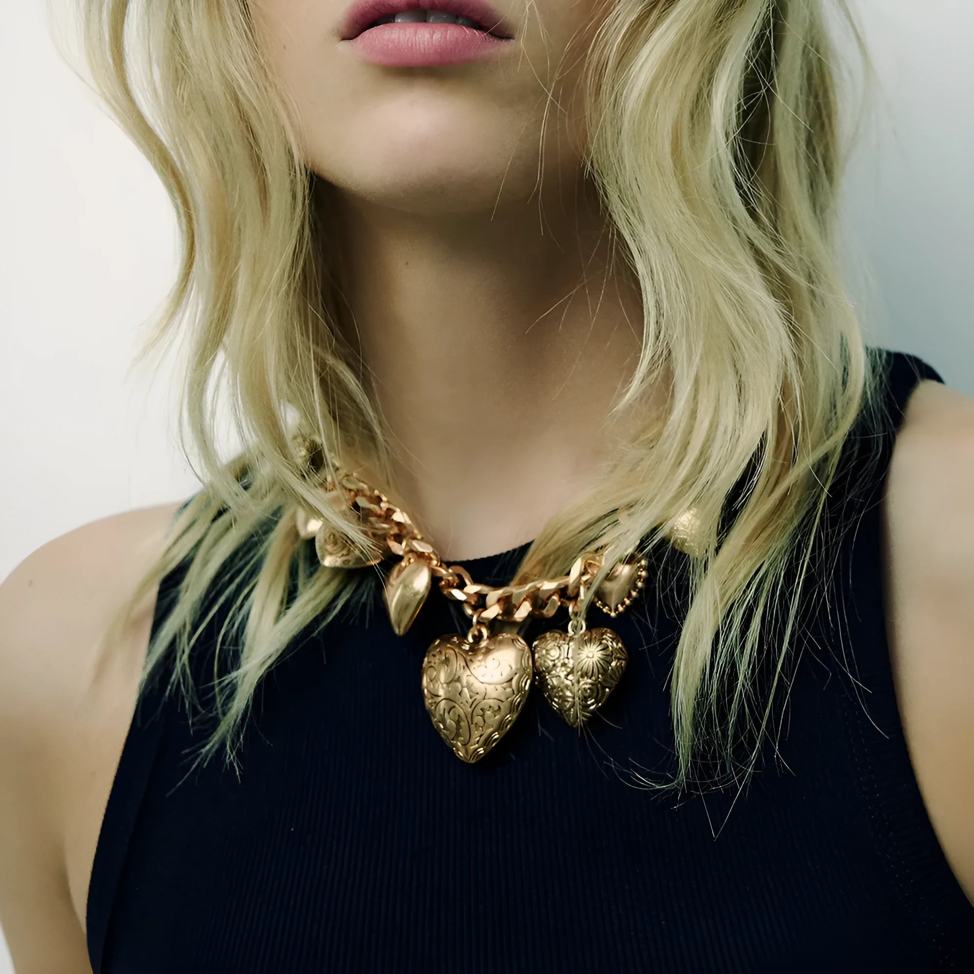 Carved heart pendant necklace in gold finish with exaggerated style on metal chain