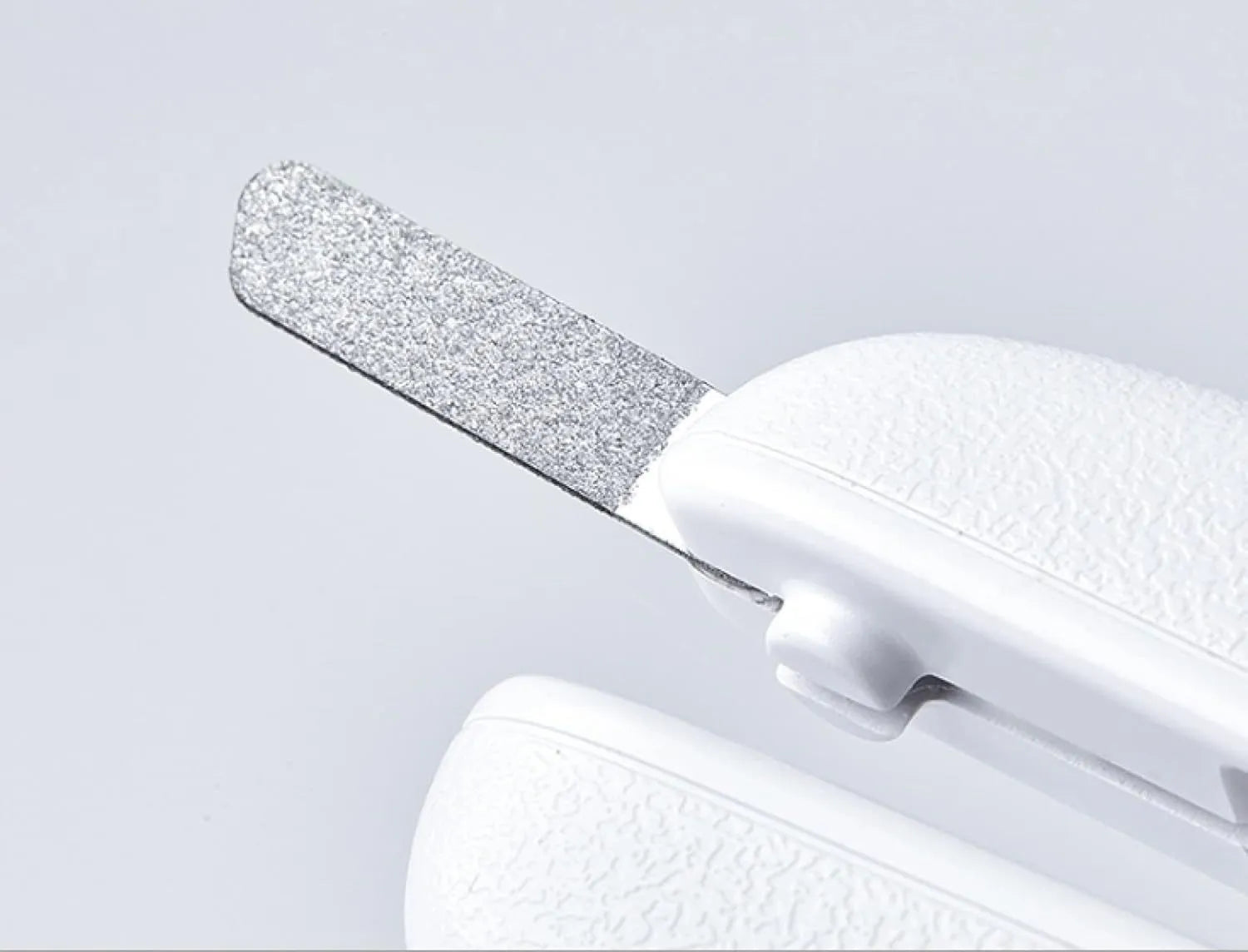 White pet nail clippers with LED light and transparent splash guard open, showing the triangular steel blade.