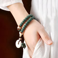 White jade and green sandalwood Bodhi seed bracelet with double ring safety buckle and lotus design.