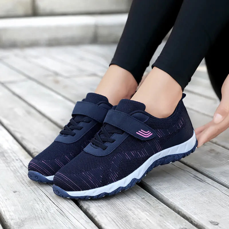 Women's grey purple breathable mesh shoes with a velcro strap and wedge heel on a composite sole.