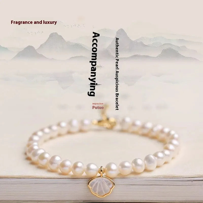 Women's freshwater pearl bracelet with fan-shaped design on wrist, showing elastic and chain fastening options.