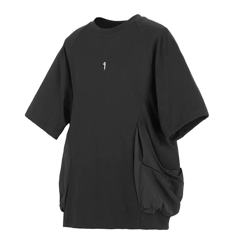 Man wearing a loose grey cotton T-shirt with large side pockets on a casual background.