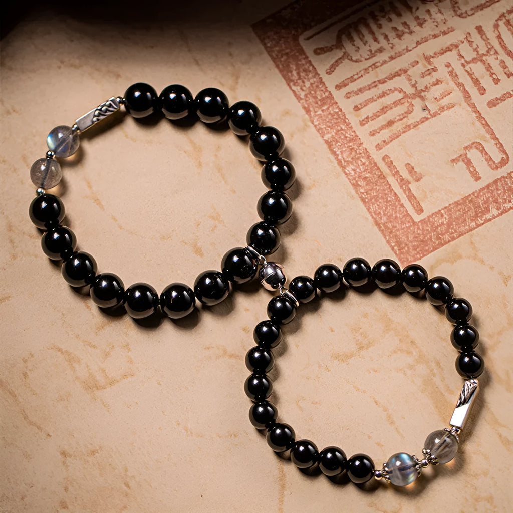 Black obsidian Buddha beads bracelets for couples, showing 8mm and 10mm bead sizes on a traditional cord.