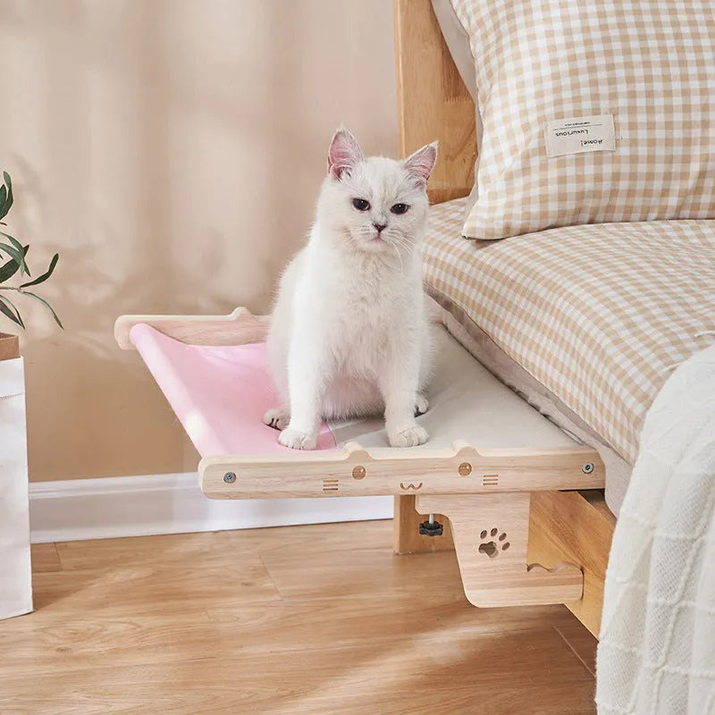 Wooden cat hanging bed hammock shown attached to a balcony railing.