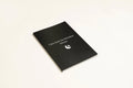 Black hardcover A5 dream journal notebook with plain pages, shown closed and open.