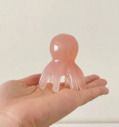 Pink octopus-shaped facial massage comb made from natural resin with eight flexible arms